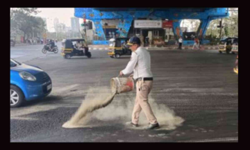 Mumbai Cop saving the “way” - Netizens praise Cop for sprinkling sand on slippery roads to prevent accidents