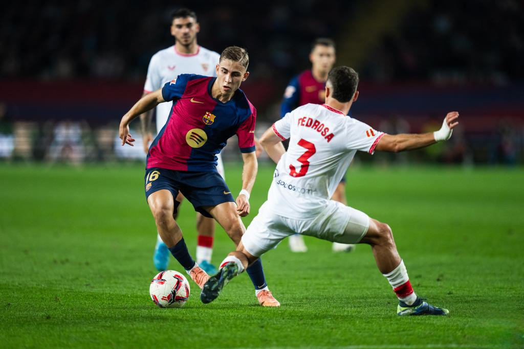 Fermin Lopez (L, front) of FC Barcelona vies with Pedrosa (R, front) of Sevilla FC during the La Liga football match between FC Barcelona and Sevilla FC in Barcelona, Spain, on Oct. 20, 2024