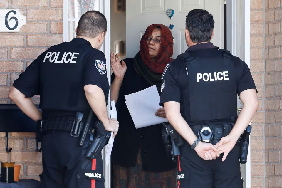 photo: Ottawa Police Service officers speak to neighbours