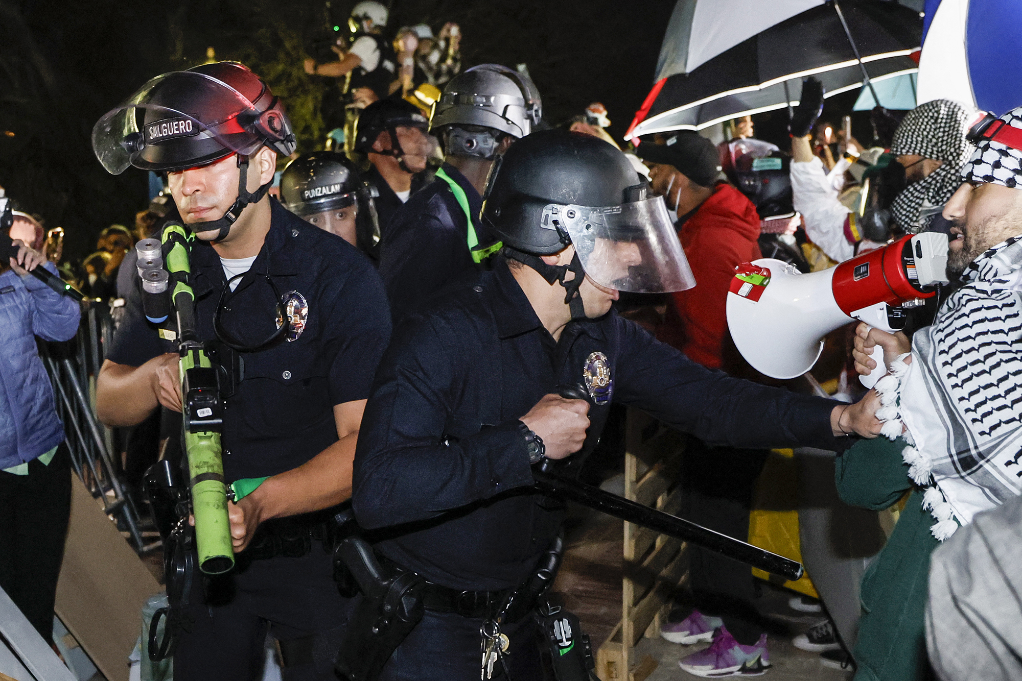 photo:Police react while pro-Palestinian students stand their ground after police breached their encampment at the campus of the University of California, Los Angeles, California, early on May 2. 