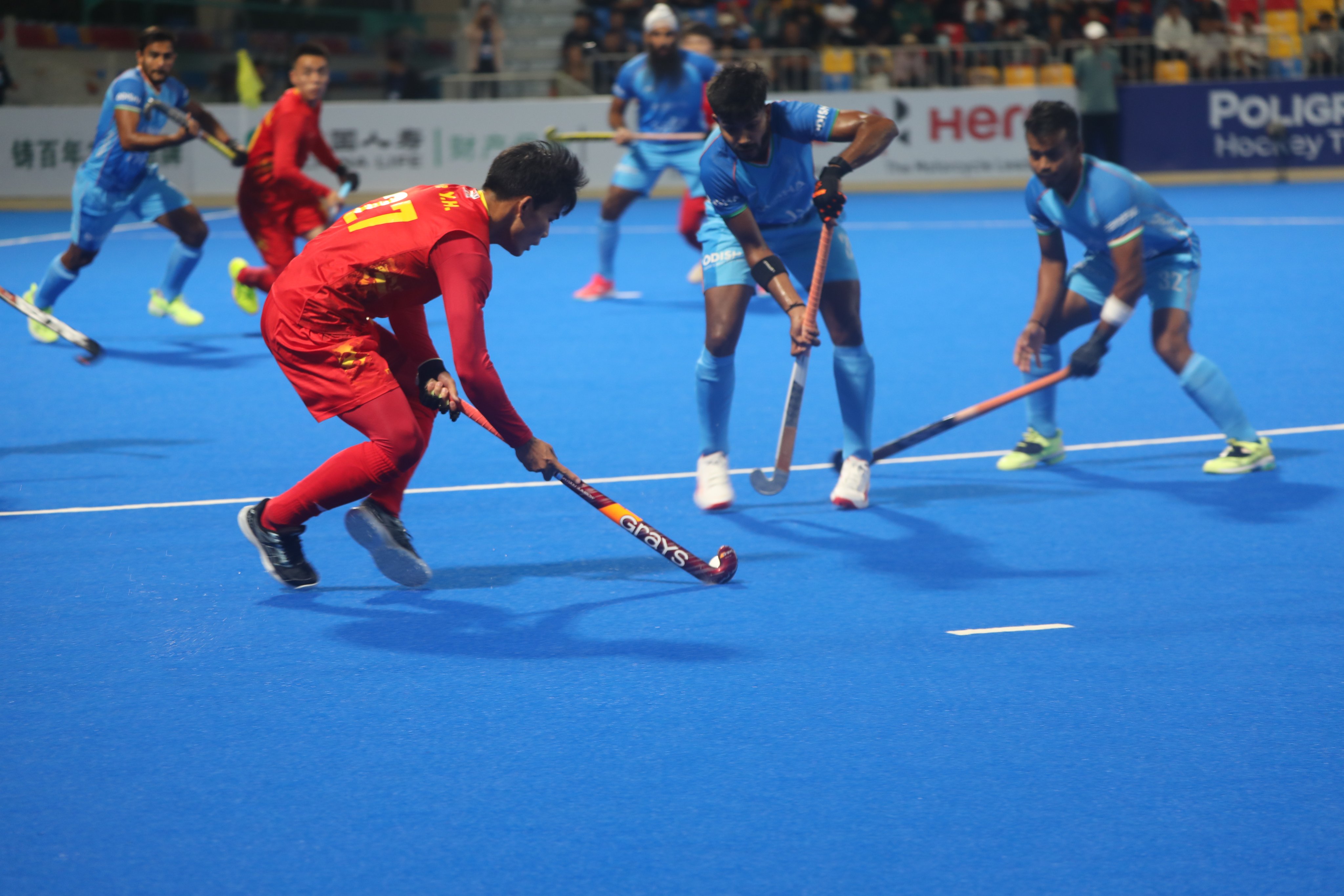 China hockey player with Indian player defending him