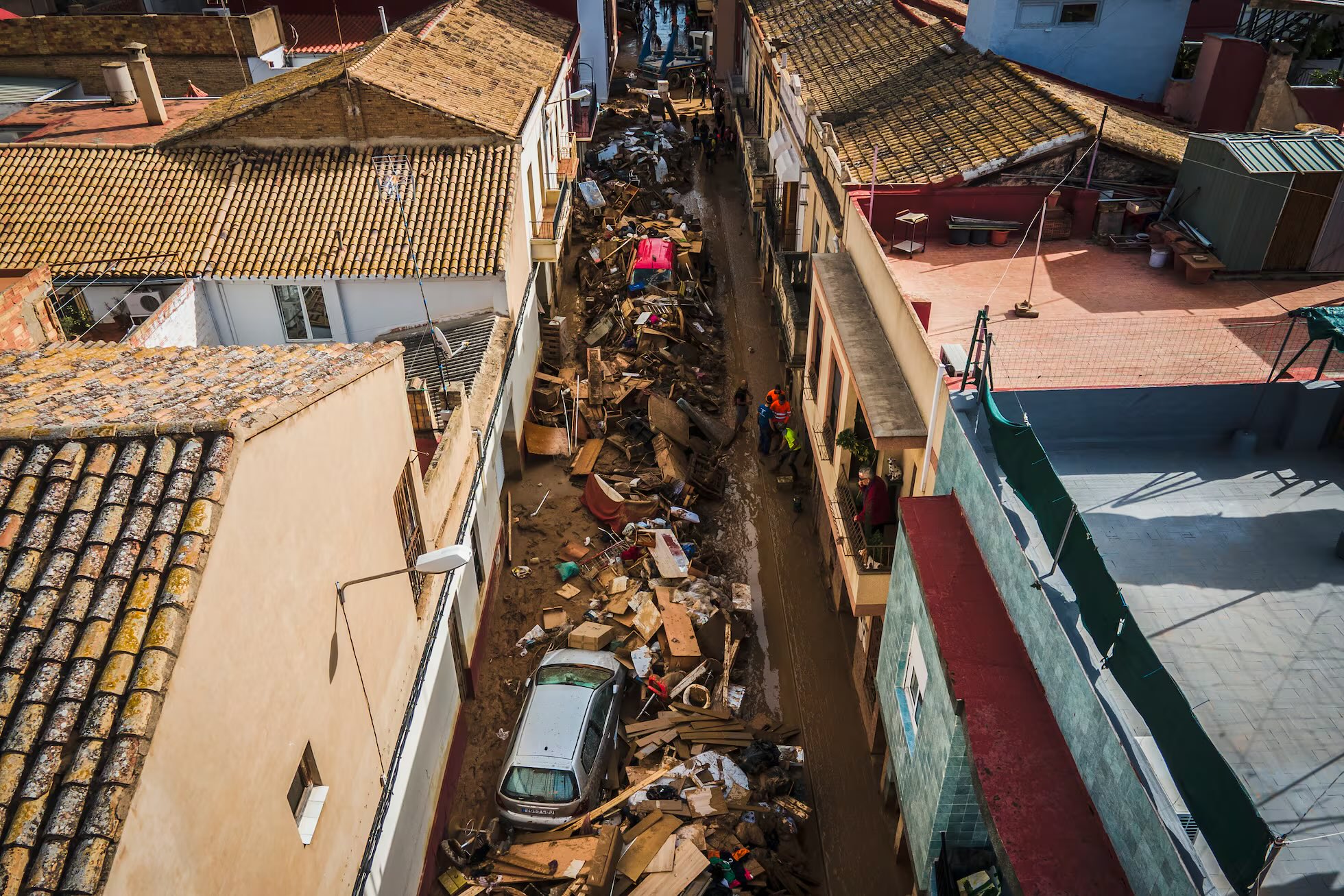 A police officer checking inside piled up vehicles for victims in the aftermath of the flooding on Saturday