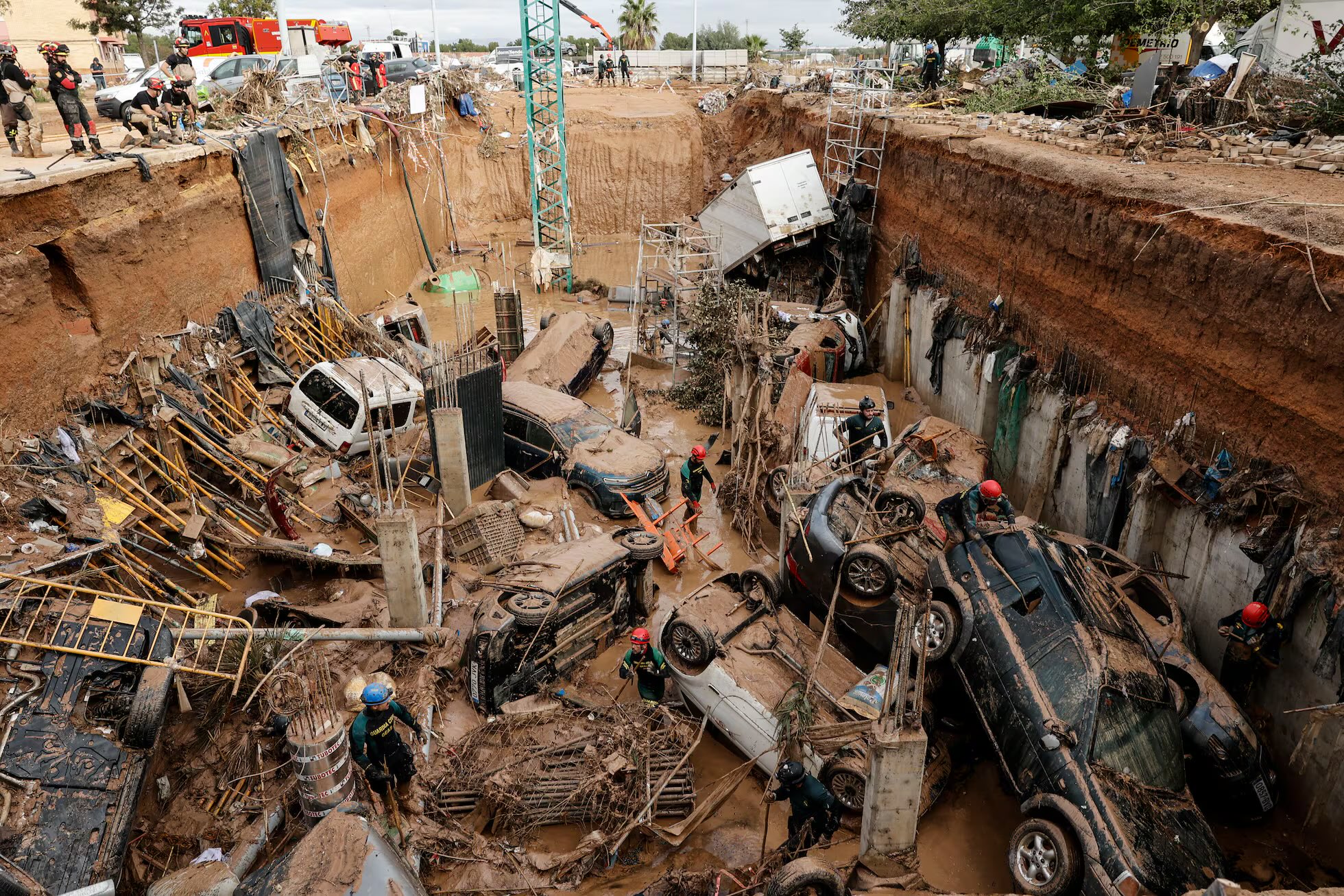 Cars are piled high on a mud-sodden street in Valencia after the region was hit by deadly floods