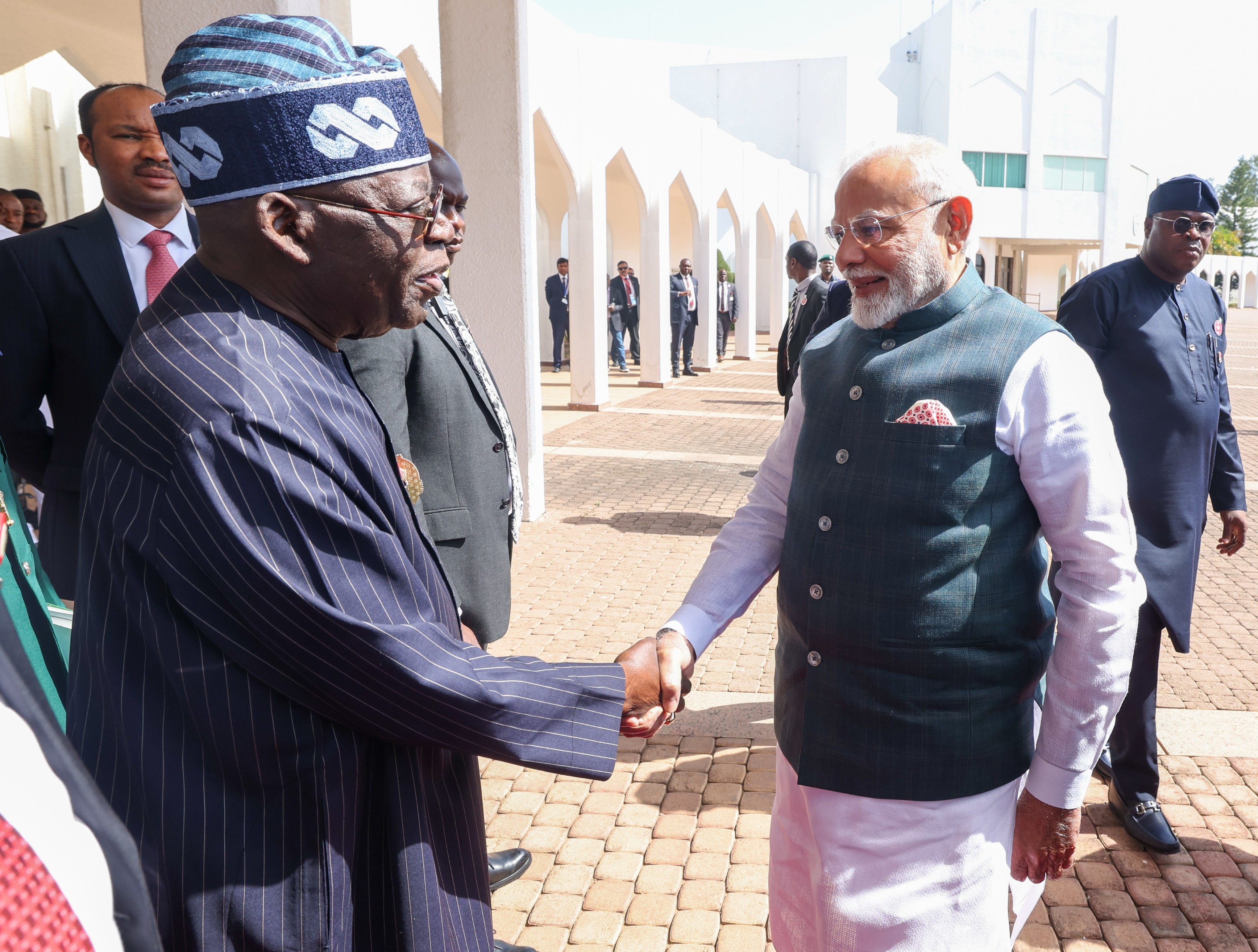 Prime Minister Narendra Modi shaking hands Nigerian President Bola Ahmed Tinubu in road.