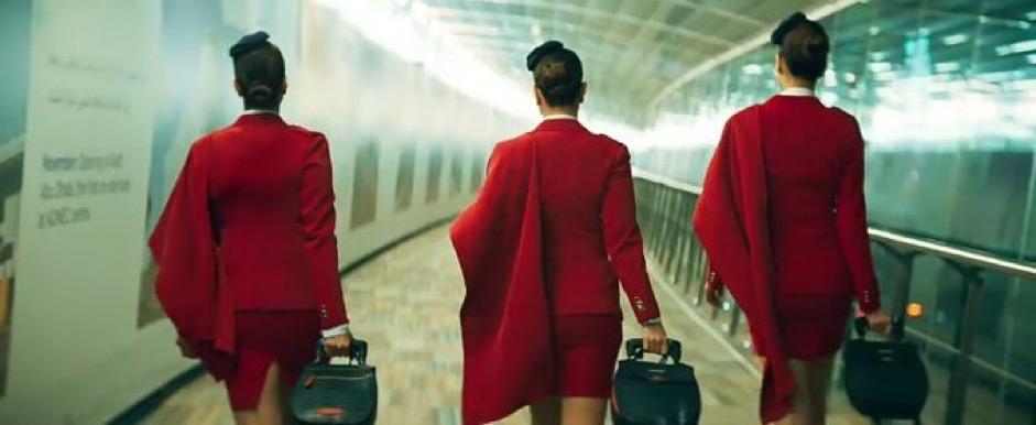 THE CREW's promo offers a sneak peek at the leading ladies looking effortlessly stylish in their Red blazers and skirts, with stroller bags in hand and black flight attendant hats.