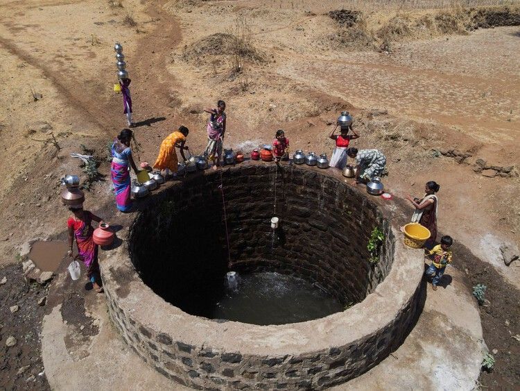 people gathered to take water from a well