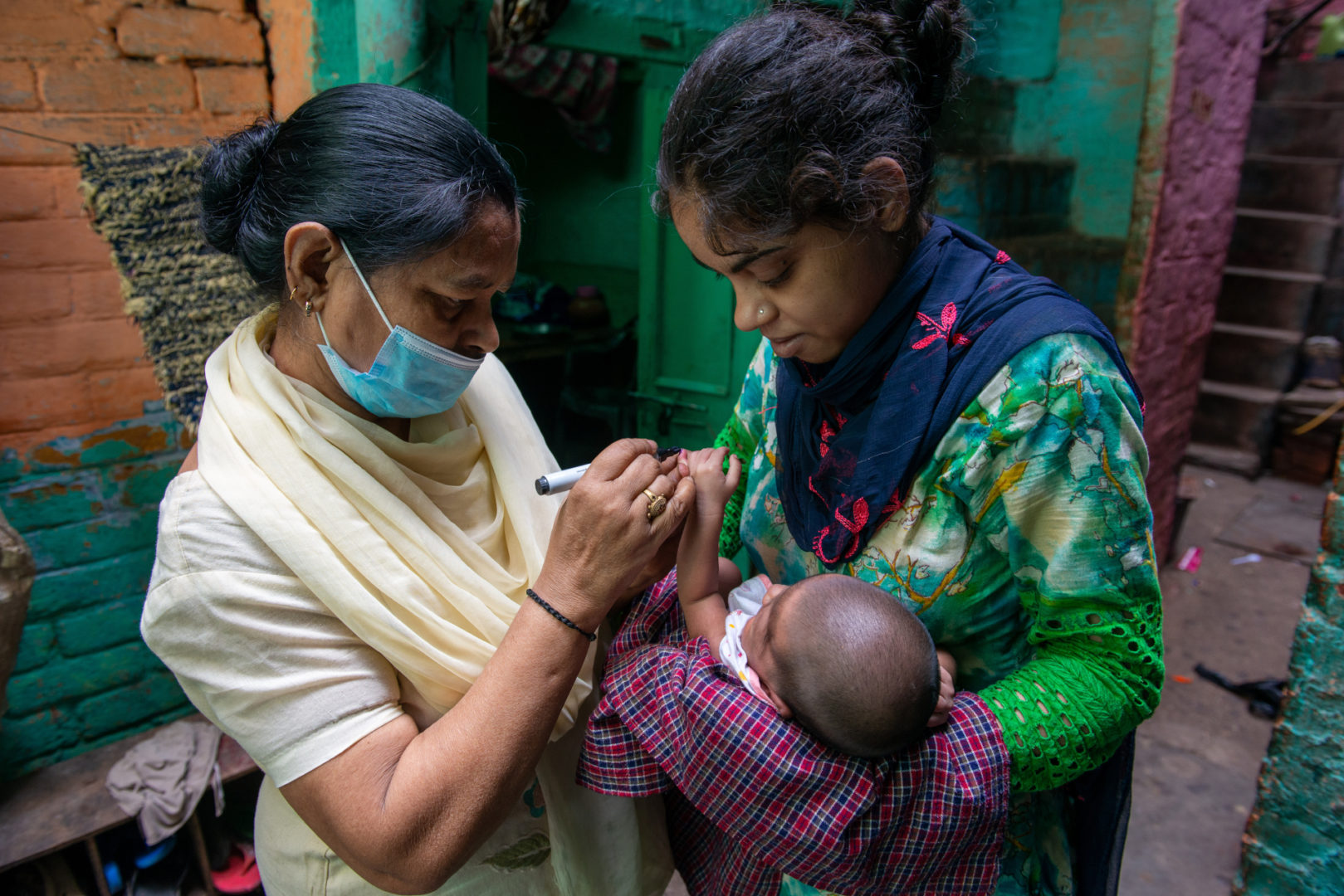 A photo of Accredited Social Health Activists (ASHAs) visiting homes in a community.