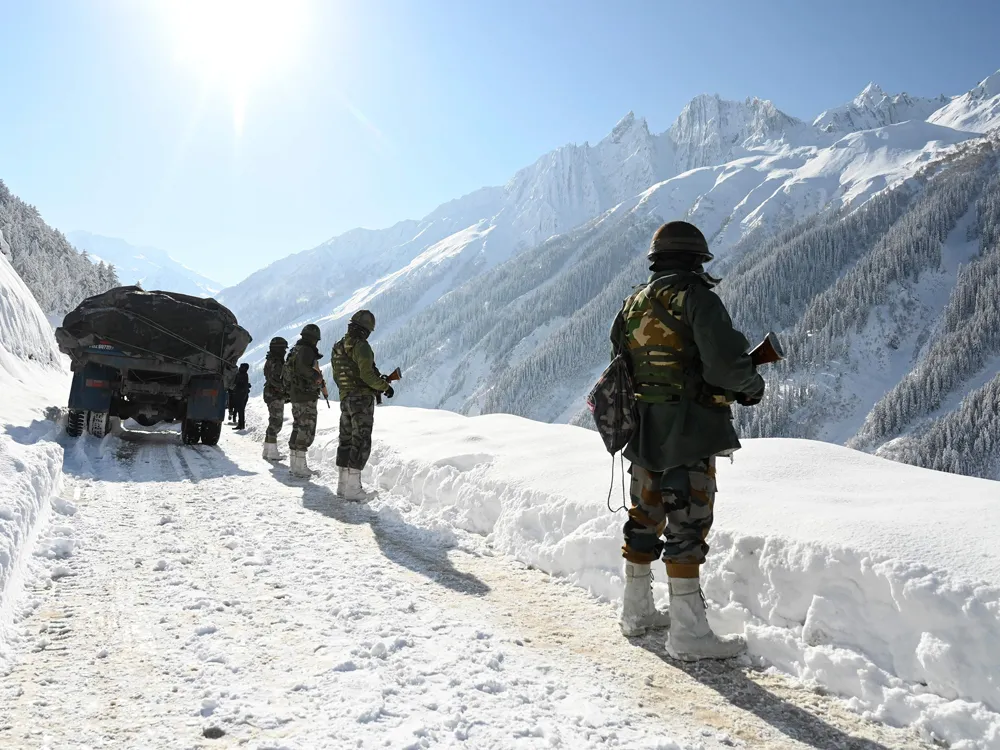 Indian soldiers walk along a road near Zojila mountain pass that connects Srinagar to the union territory of Ladakh, bordering China 