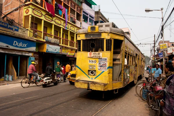 Tram and public bus on city road with view of old office buildings at Esplanade area of Kolkata India  