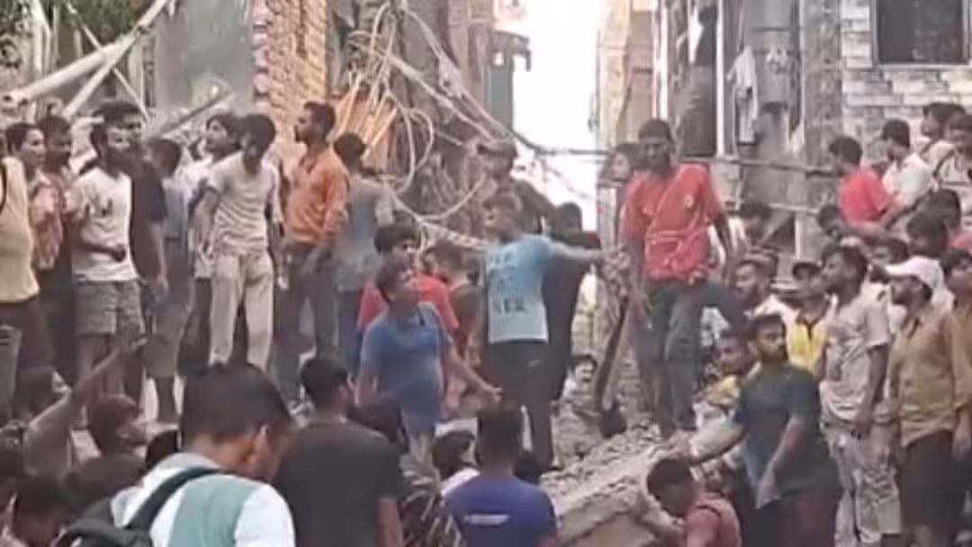Rescuers and residents searching through rubble after a five-storey building collapsed in Seemapuri, Delhi