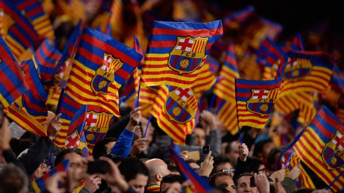 crowd cheering for Barcelona with flags in hand.